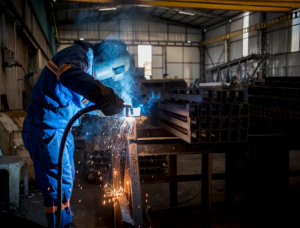 Welding fumes surrounding industrial equipment while a welding fume extraction system captures airborne contaminants