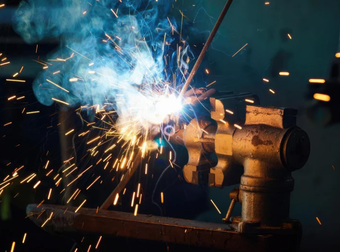 Welding fumes with a welding fume extraction system with an extraction arm capturing fumes at the source